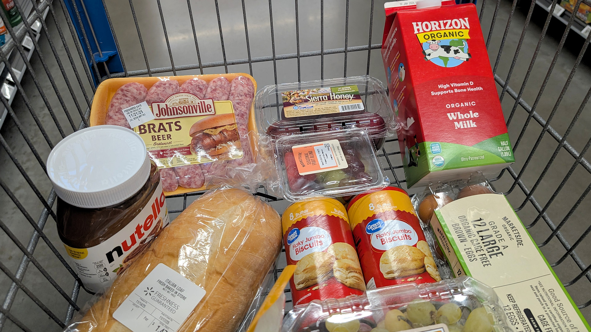 Typischer Supermarkt Einkaufskorb mit Nutella, Brot, Milch, Obst, Eiern und anderen Produkten 