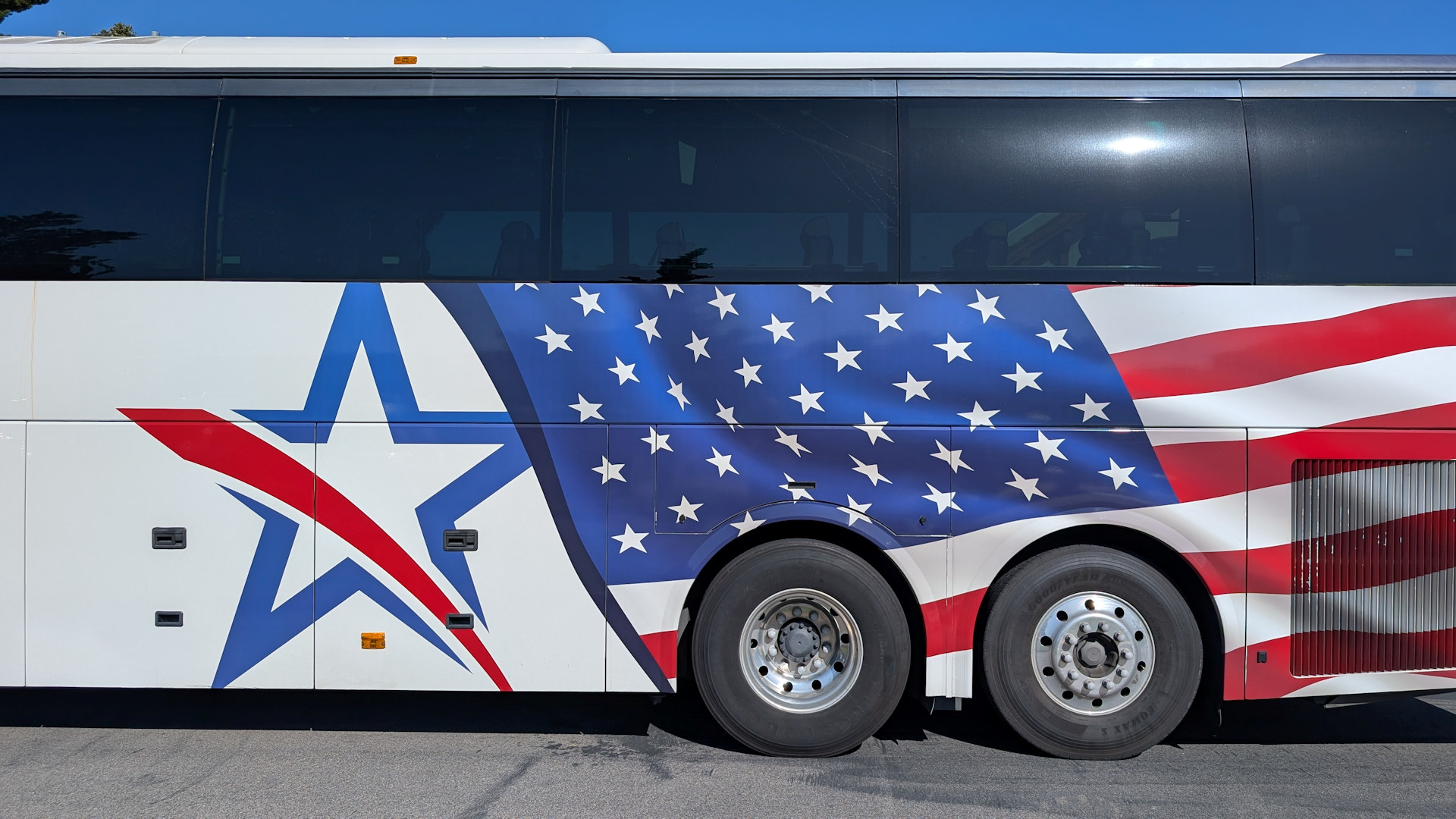 Detail von einem dreiachsigen Reisebus mit amerikanischer Flagge