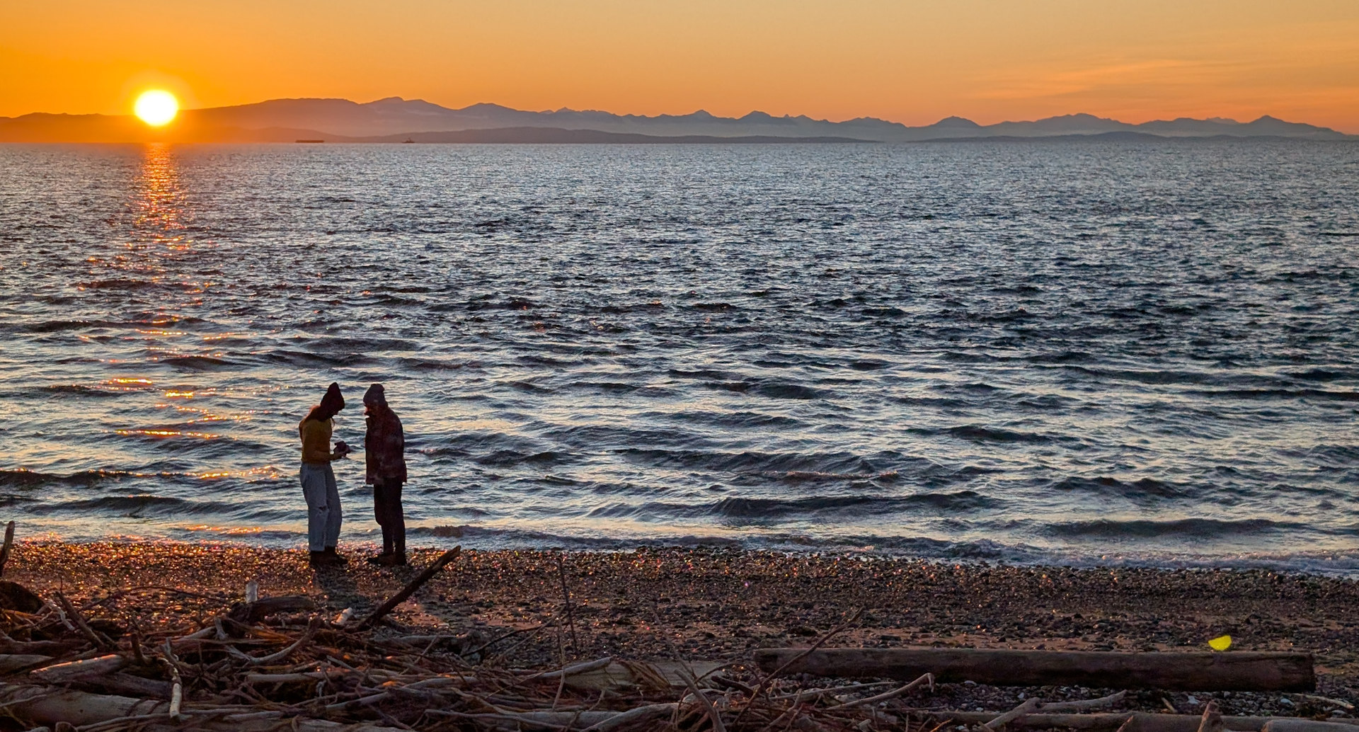 Sonnenuntergang mit zwei Spaziergängerinnen am Strand von Point Roberts 