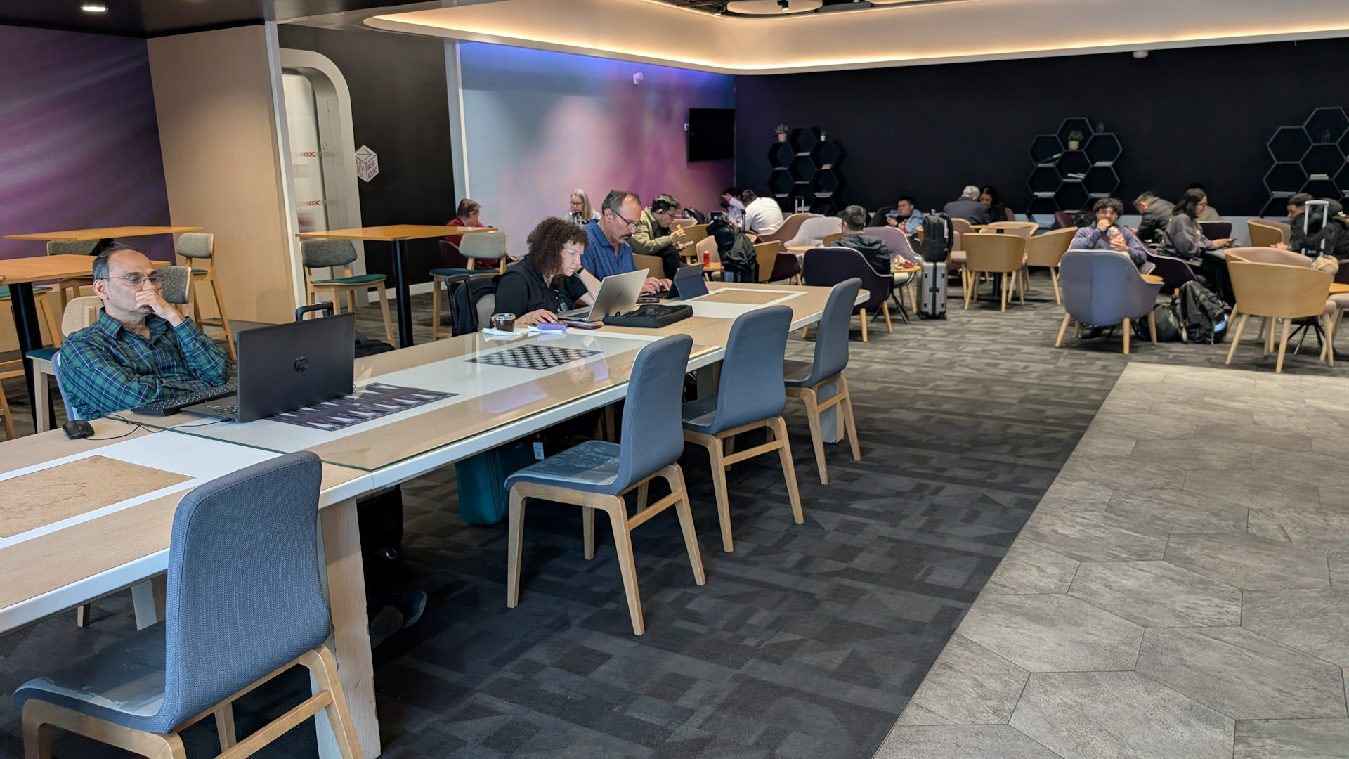 Einfacher Wartebereich mit Stühlen und Tischen im Yotel Air Charles de Gaule Flughafen Paris