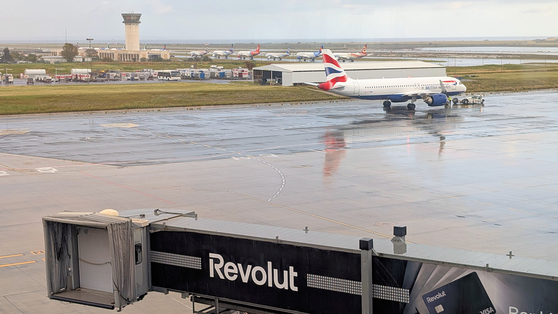 Blick von der Skala Lounge Larnaka aus auf das Rollfeld vom Flughafen auf dem eine abflugbereite Maschine steht  