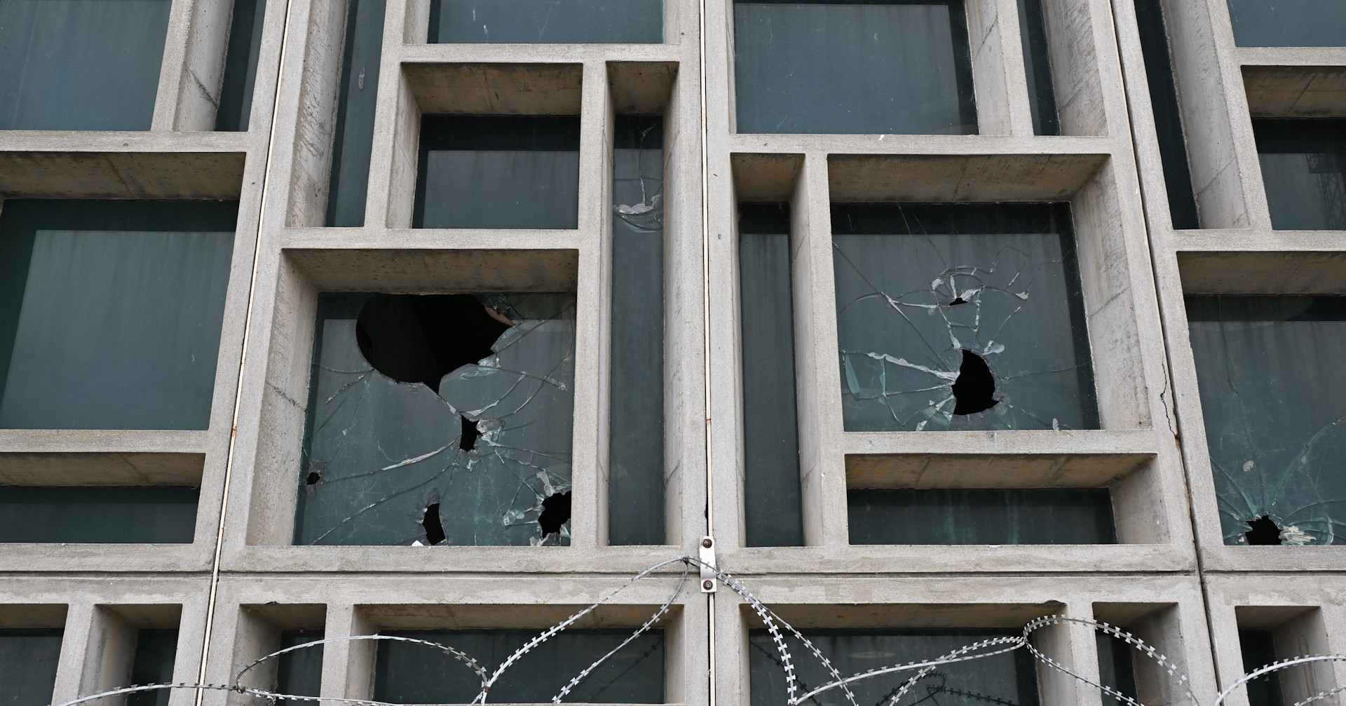 Detailaufnahme der Fassade vom Flughafen Nikosia mit Einschlusslöchern im Glas 