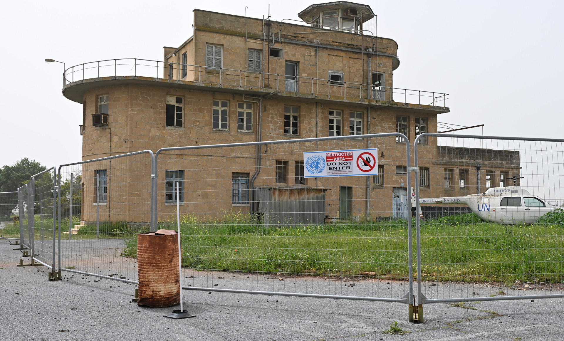 Ehemaliger Tower vom Flughafen Nikosia mit davor parkenden Hubschrauber Wrack 