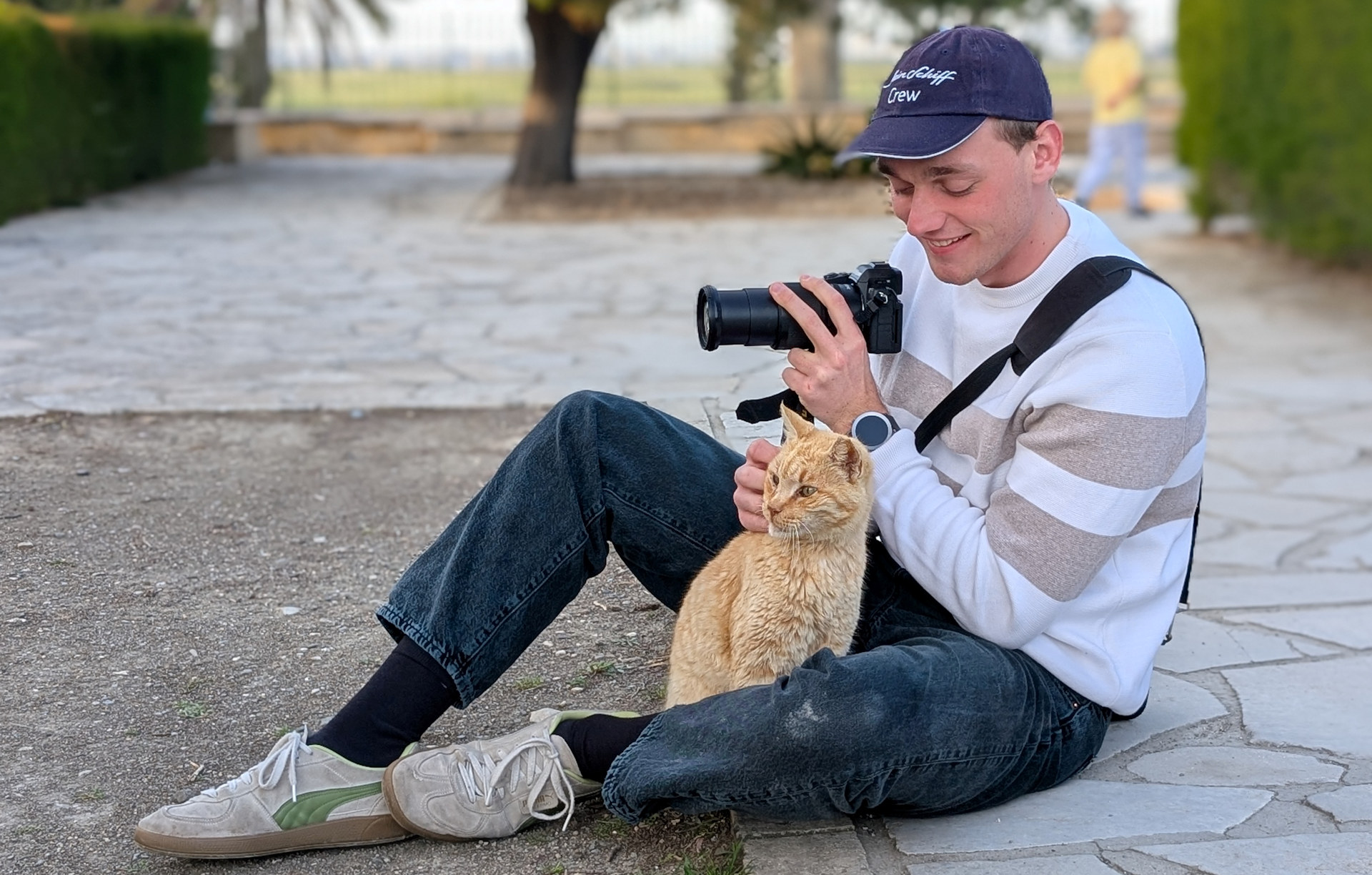 Junger Fotograf mit Katze im Schoss 