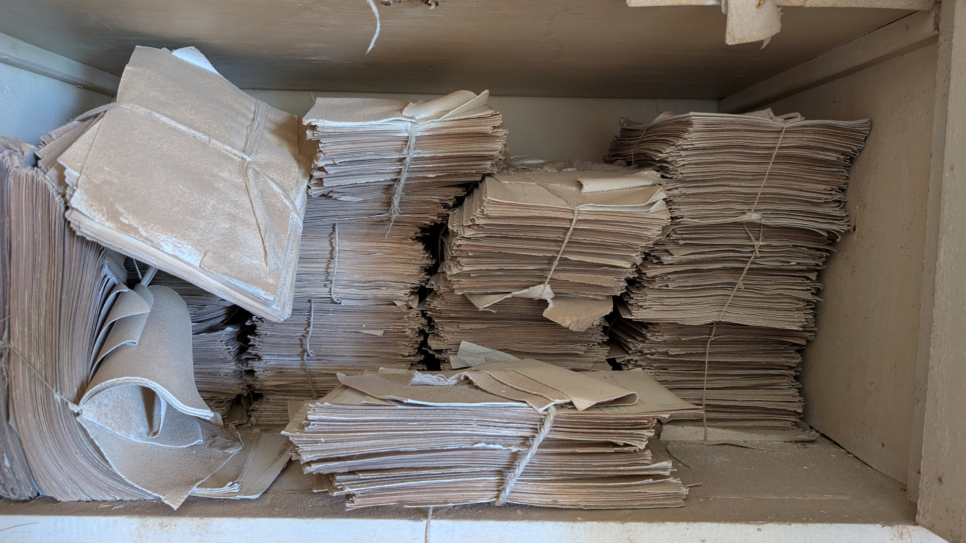 Verstaubte Dokumente die mit einem Bindfaden zusammen gehalten werden