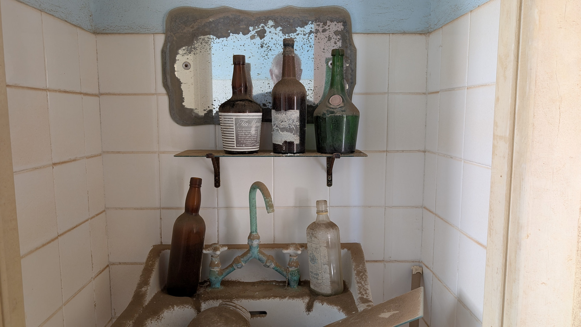 Badezimmer Nische mit blind gewordenem Spiegel und fünf Glasflaschen