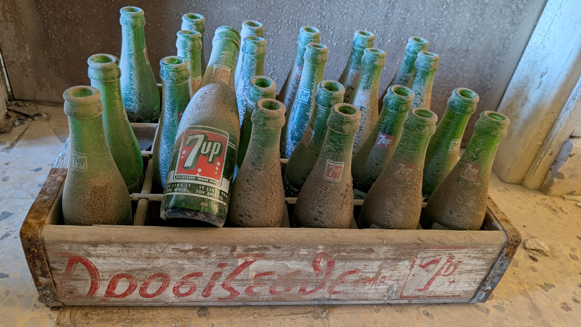 Kiste mit grünen leeren eingestaubten Seven Up Flaschen