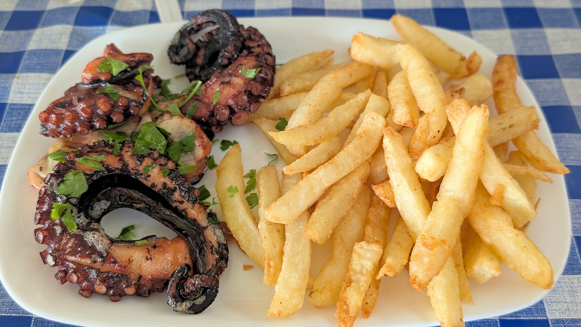 Portion Calamari mit Petersilie bestreut und goldene Pommes 