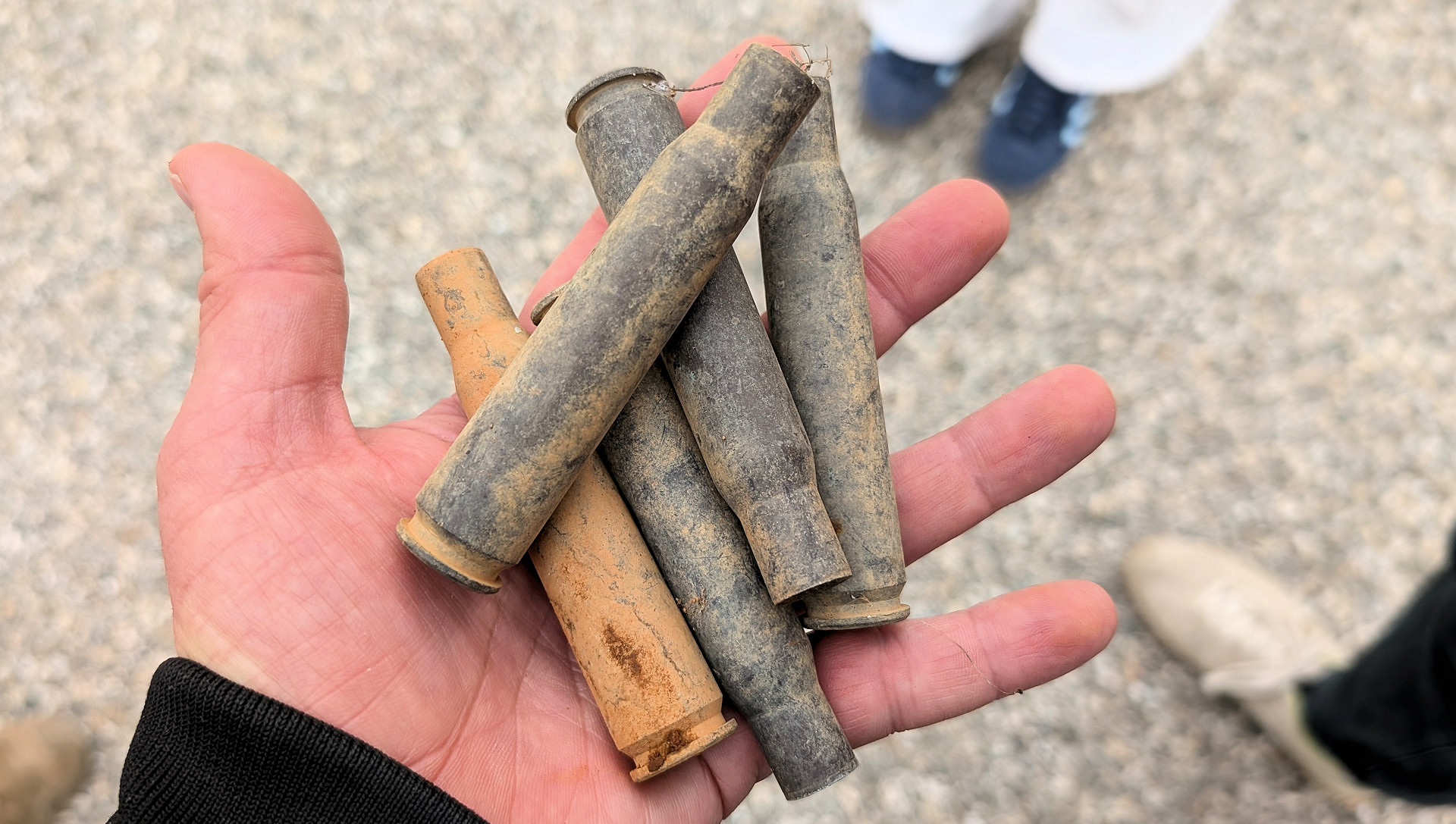 Hand hält 5 grosskalibrige Patronen 