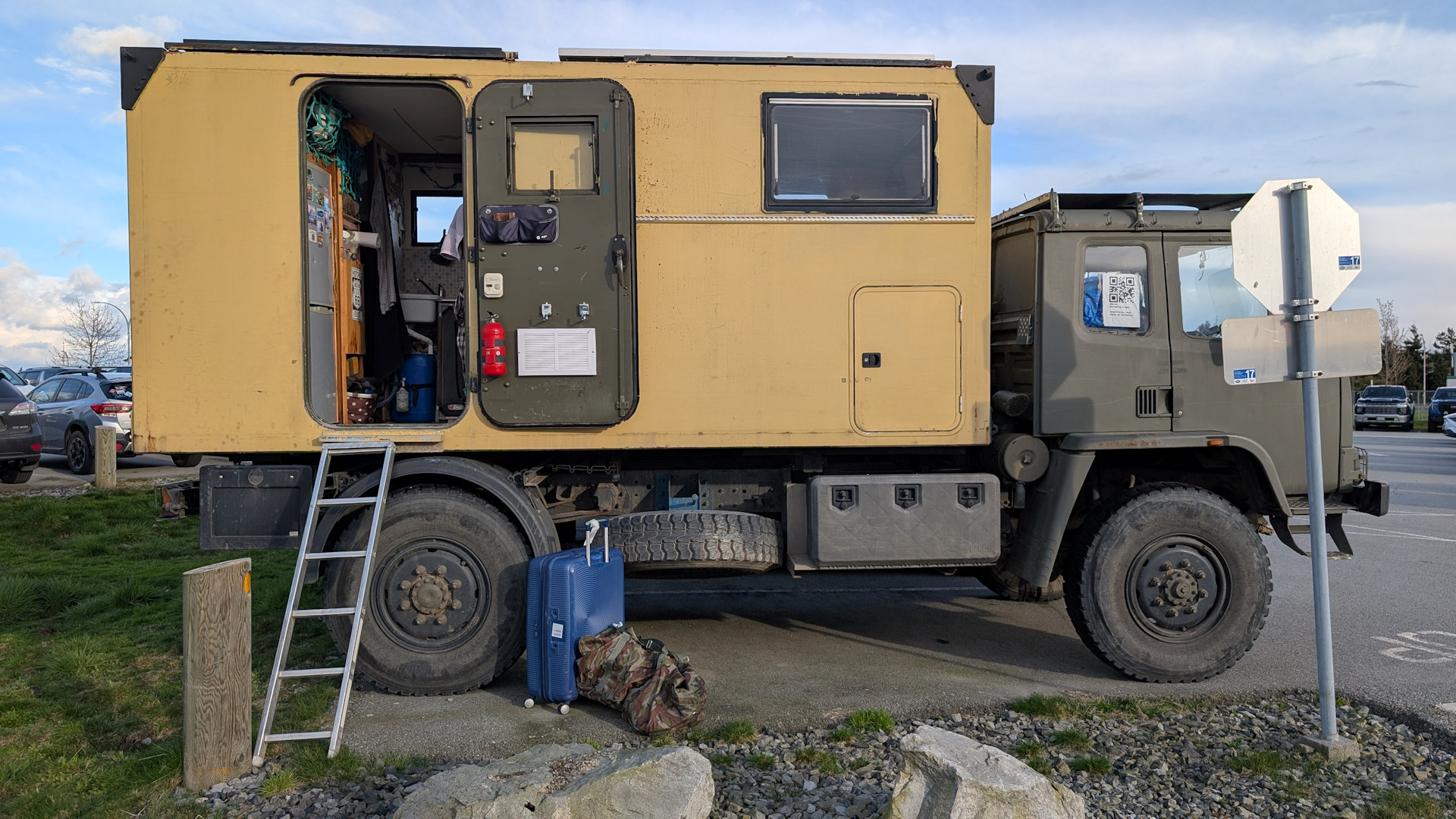 LKW mit offener Kabinentür und einem Koffer und einer Tasche davor 