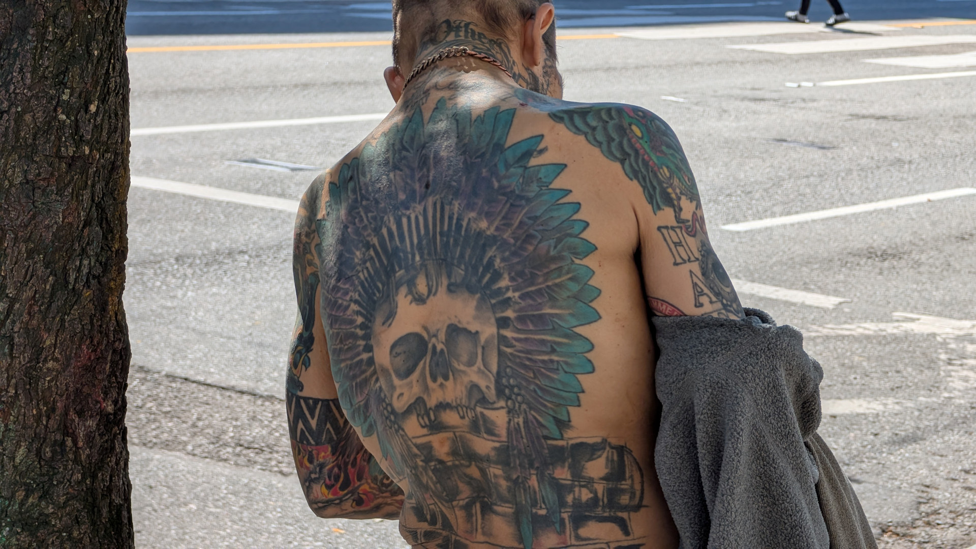 Drogenabhängiger Mann in East Hastings Vancouver mit einem Totenkopf Tattoo auf dem Rücken