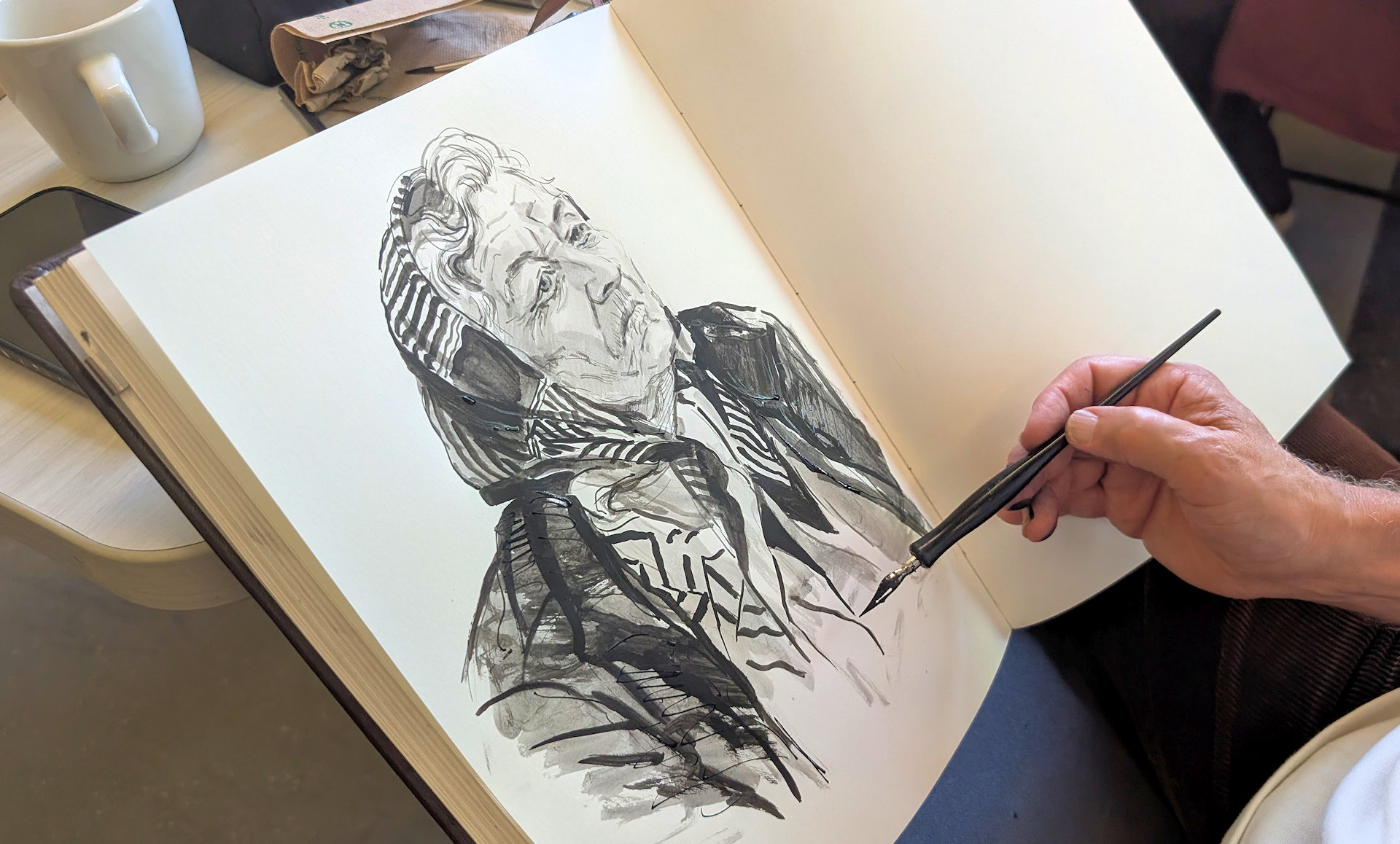 Portrait einer ernst blickenden alten Frau mit Kopftuch in schwarz weiss schräg fotografiert in einem Skizzen Buch