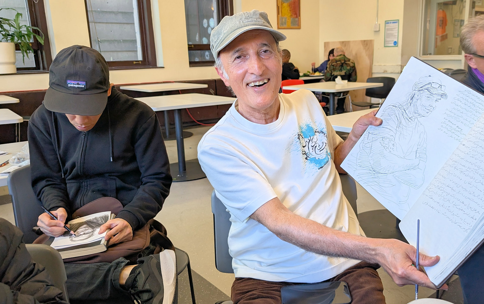 Künstler Reza Doust mit seinem Skizzen Buch
