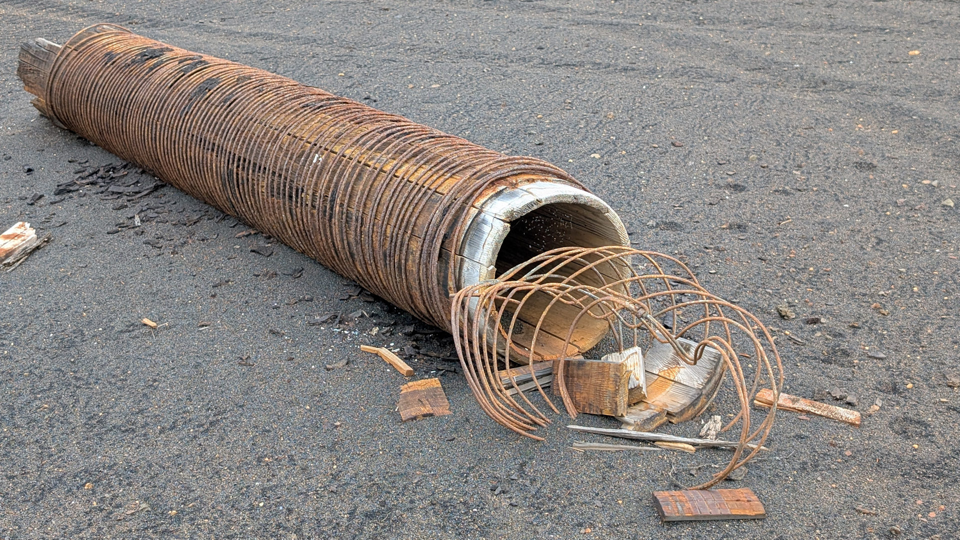 Altes Holzrohr was mit rostigem Stahldraht umwickelt ist
