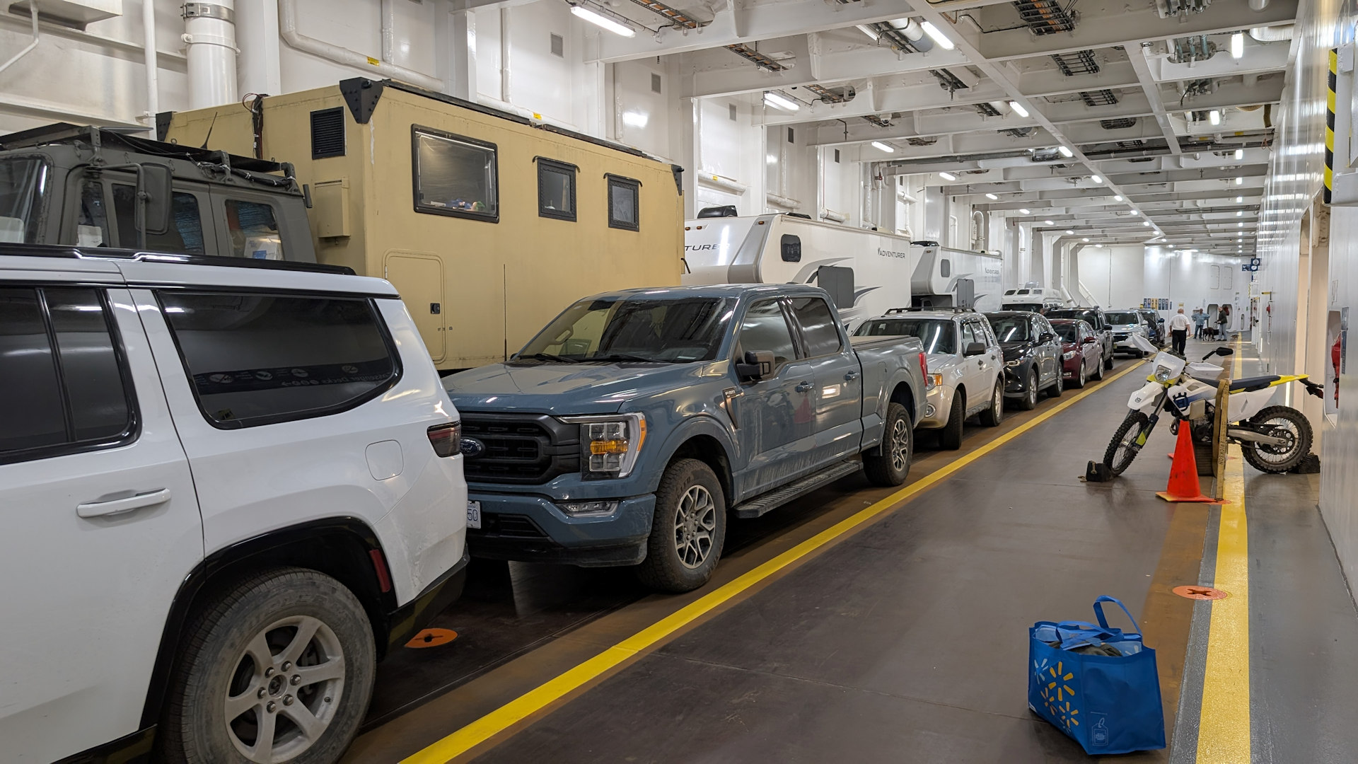 Fahrzeugdeck der Autofähre Northern Expedition mit Autos, Campern und einem Motorrad