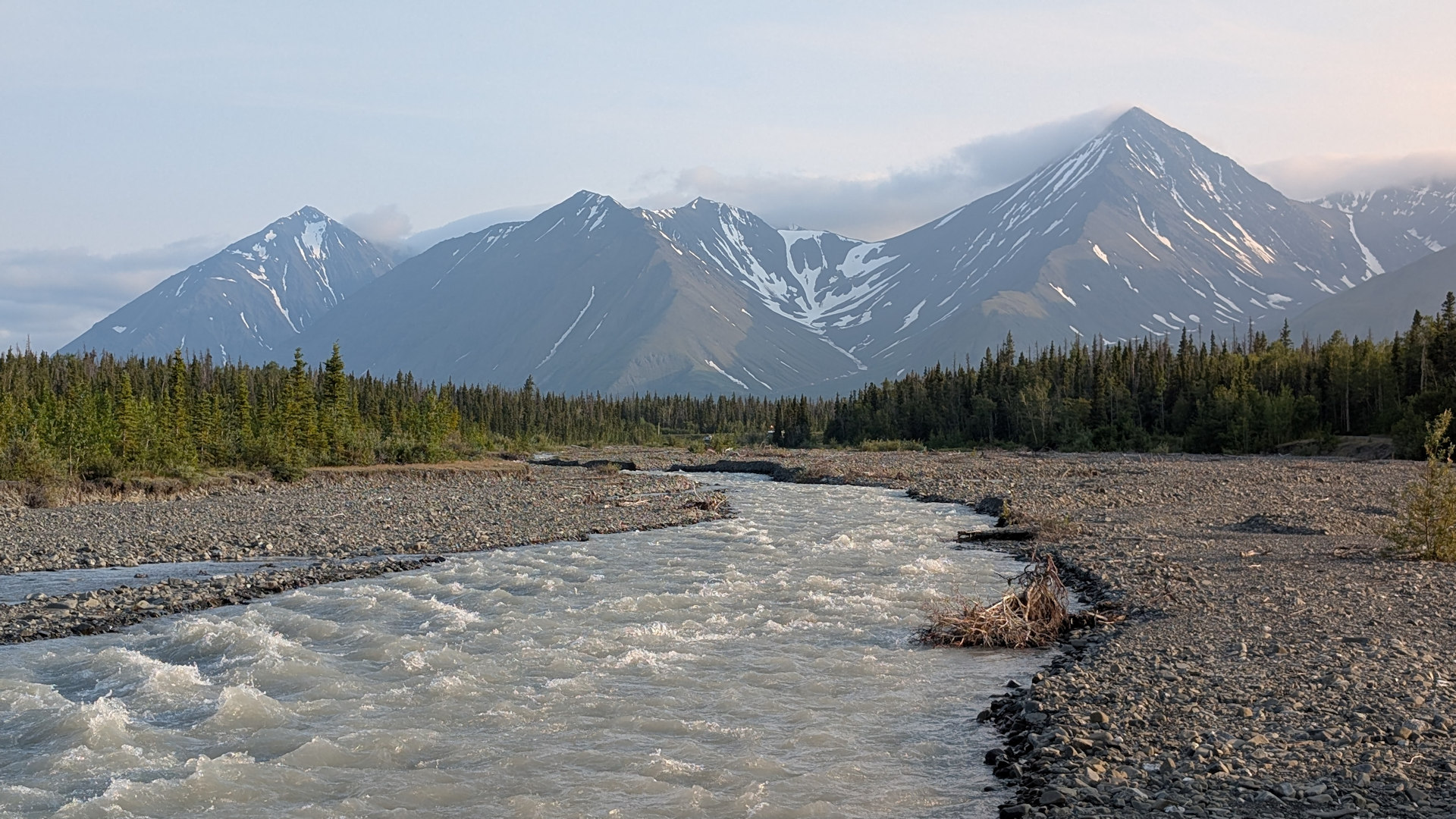 Schneebedeckte Berge des Yukon mit wildem Fluss im Vordergrund