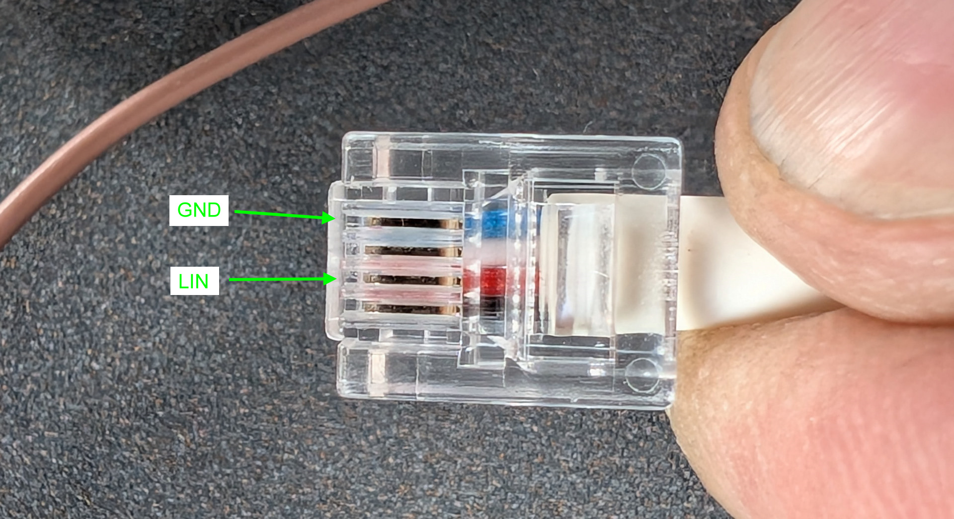 Nahaufnahme von einem RJ11 Telefonkabel mit 4 Adern und zusätzlicher Beschriftung für GND und LIN