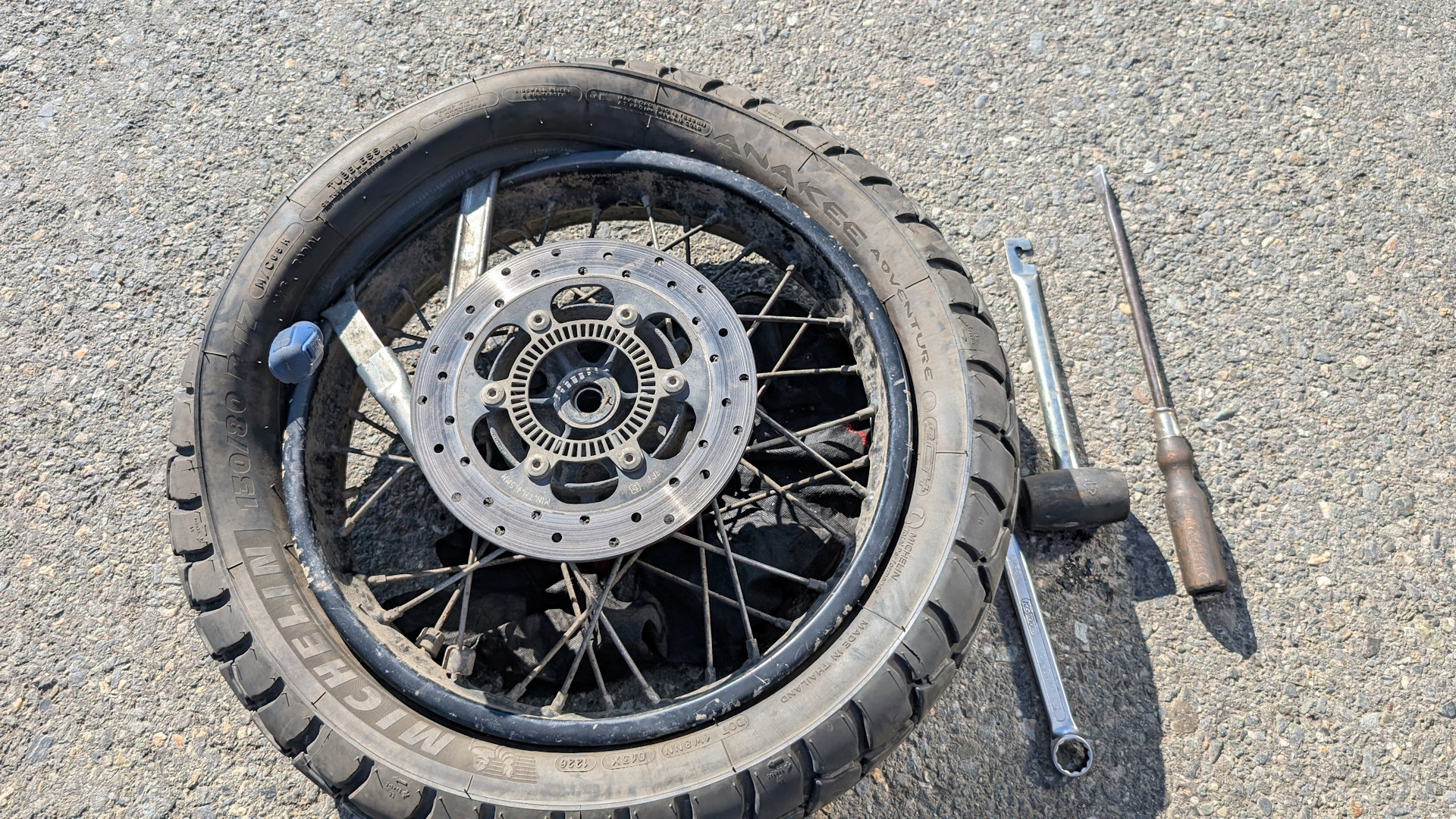 Reifen von einem Motorrad wird von einer Felge gezogen 