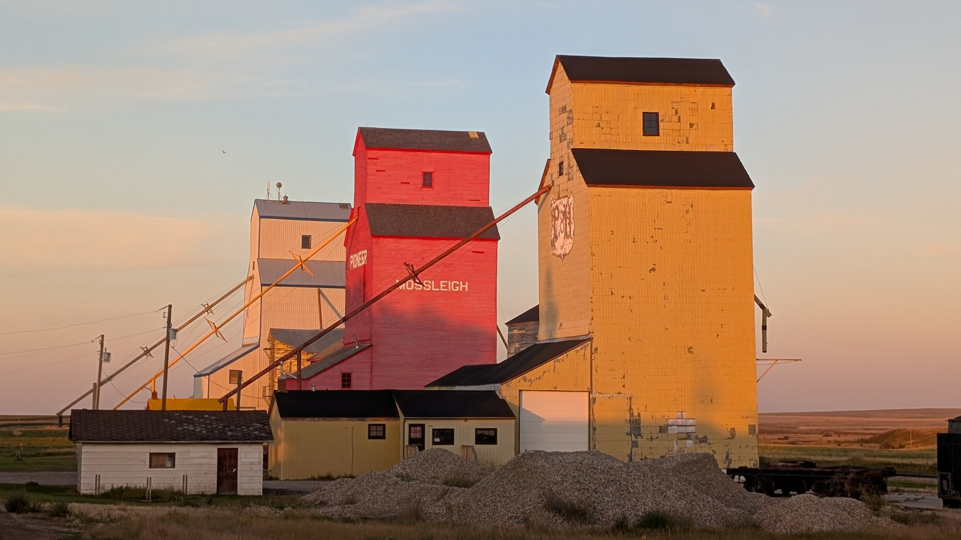 Abendsonne beleuchtet drei Grain Elevator in Mossleigh