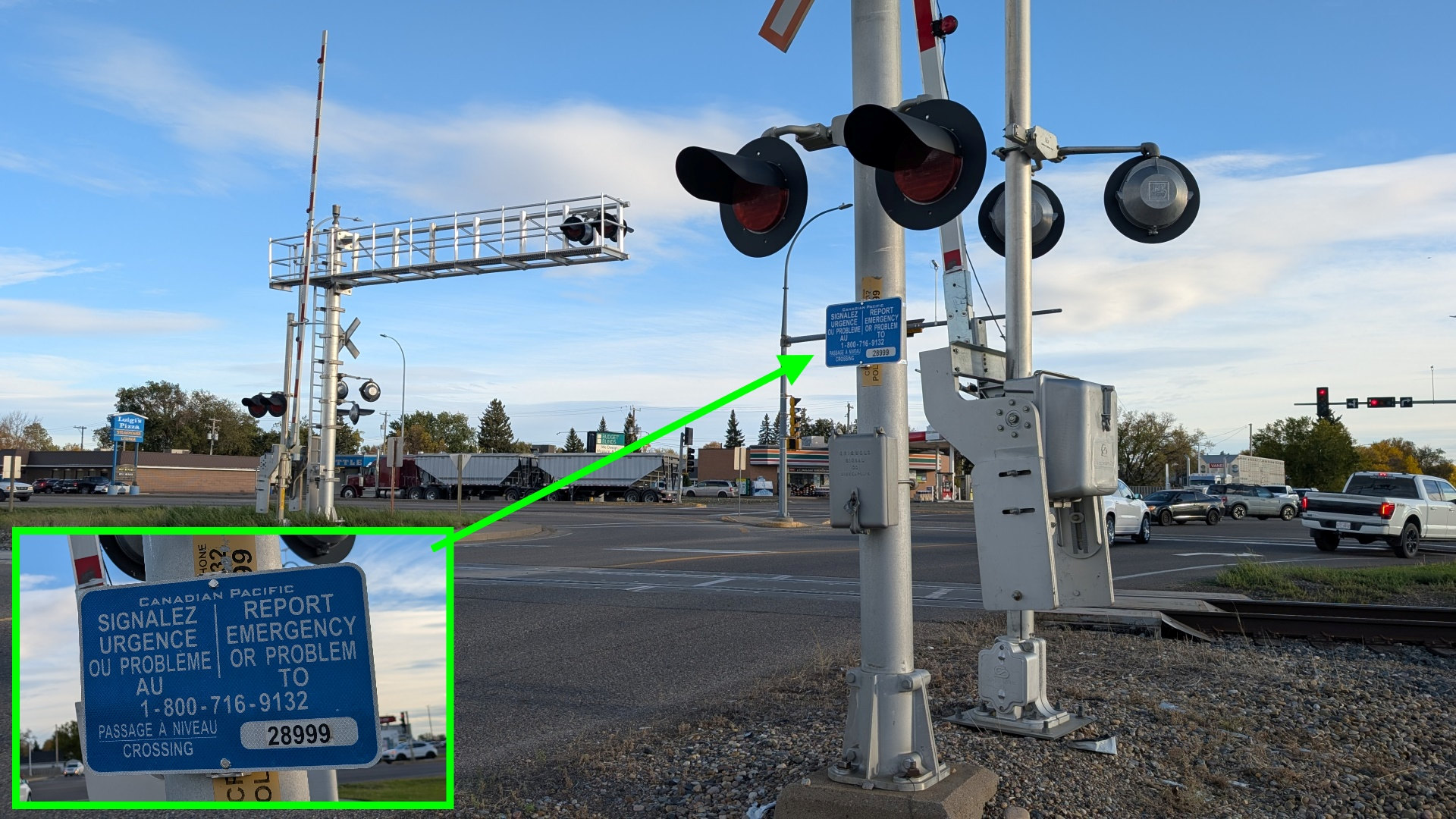 Bahnübergang in Kanada wo grafisch ein Schild mit einer Notrufnummer hervor gehoben wurde 