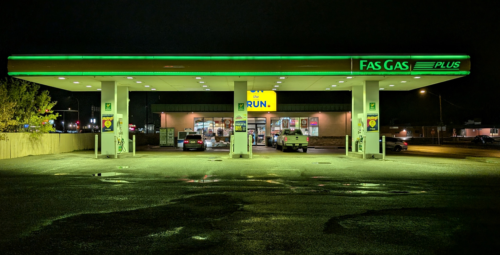 Grün leuchtende Fas Gas Tankstelle Nachts in Taber, Alberta