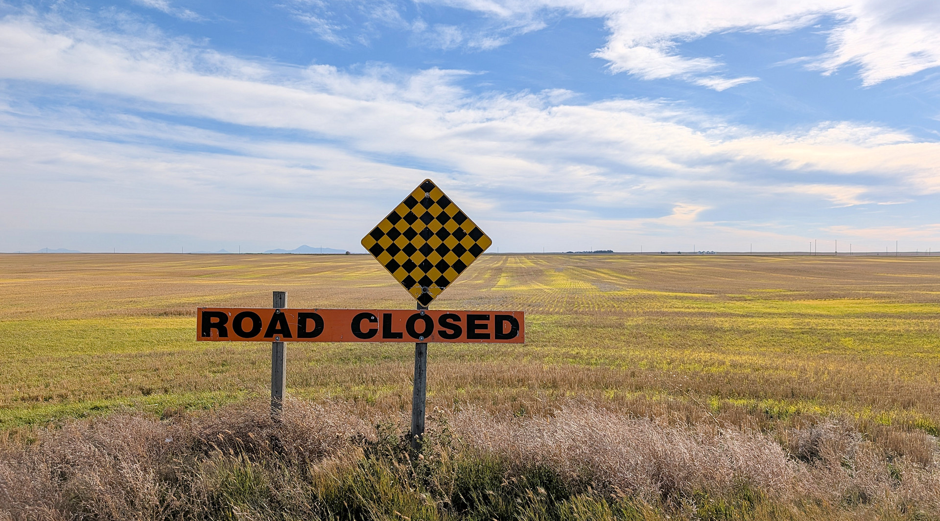 Road Closed Schild vor einem abgeernteten Feld was bis zum Horizont reicht 